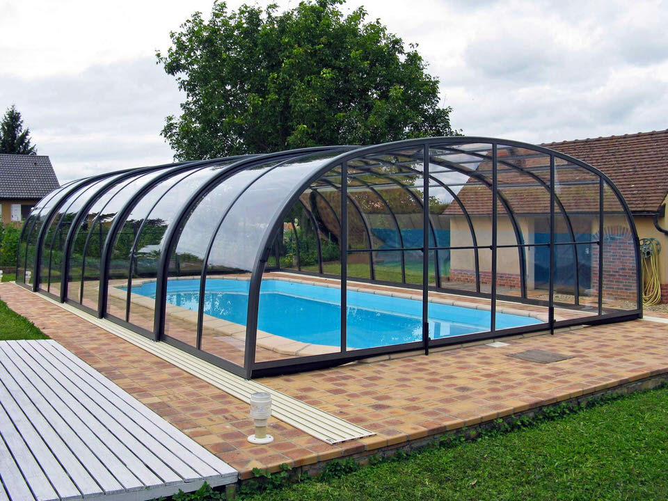 Hohe, begehbare Alukov-Poolüberdachung Laguna über einem Gartenpool