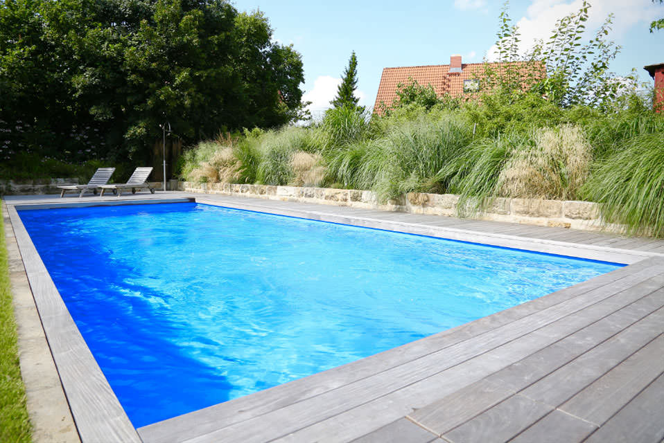 Gartenpool mit Holzterrasse, Natursteinmauer und Gräsern – Poolbau-Referenz der K.IM.S. GmbH, Raum Dresden